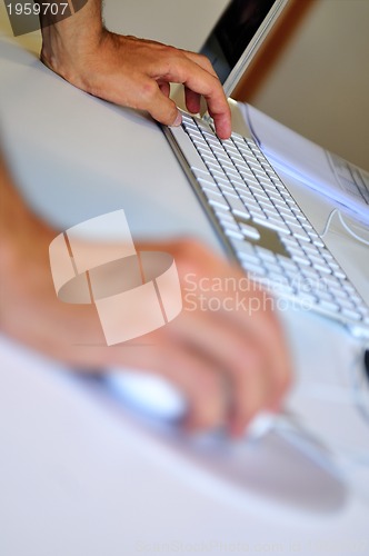 Image of lose-up of male hand on mouse while working on laptop