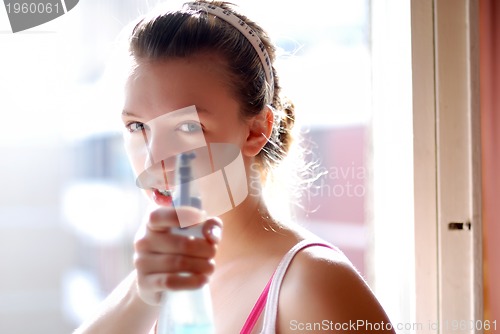 Image of Young woman cleaning the window