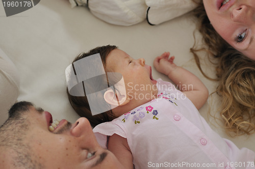 Image of young family playing with cute little baby