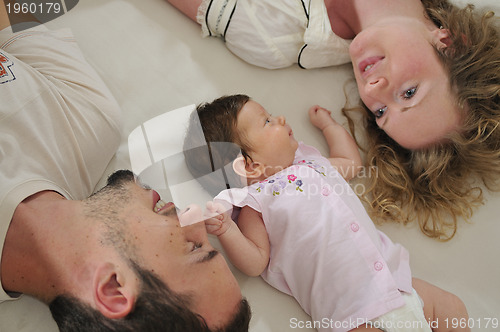 Image of young family playing with cute little baby