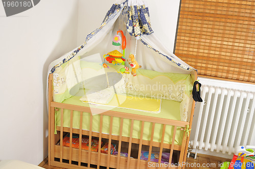 Image of baby bed with colorful toys indoor