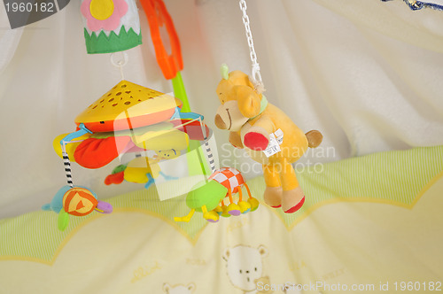 Image of baby bed with colorful toys indoor