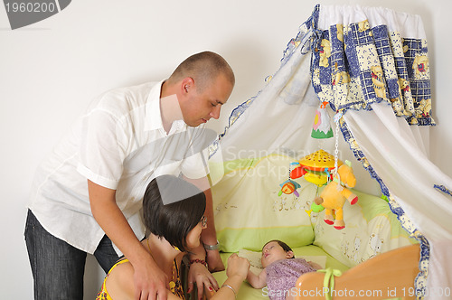 Image of young family playing with cute little baby