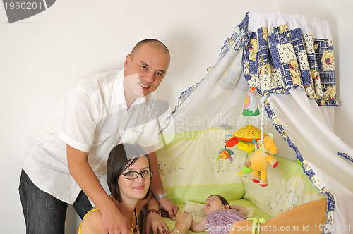 Image of young family playing with cute little baby