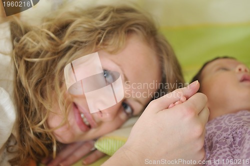 Image of beautiful young mother hold small children hand