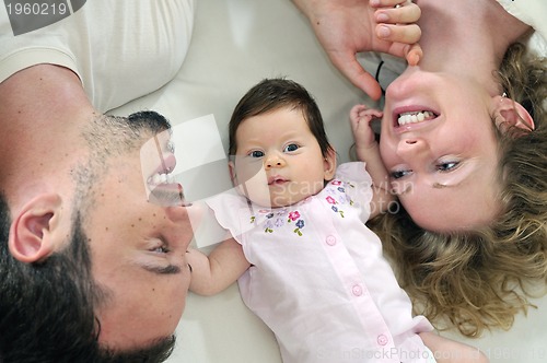 Image of indoor portrait with happy young family and  cute little babby 