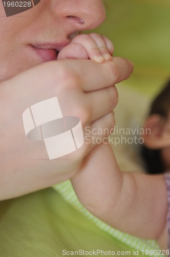 Image of beautiful young mother hold small children hand