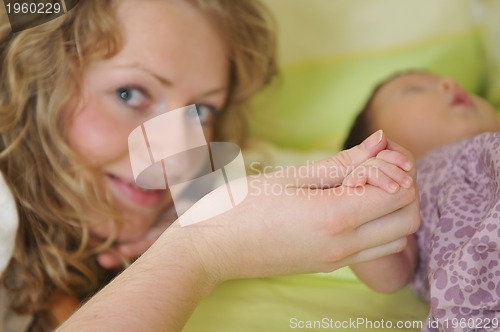 Image of beautiful young mother hold small children hand