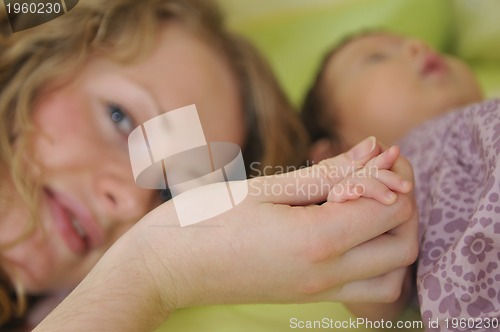 Image of beautiful young mother hold small children hand