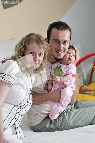 Image of indoor portrait with happy young family and  cute little babby 