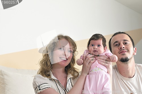 Image of indoor portrait with happy young family and  cute little babby 