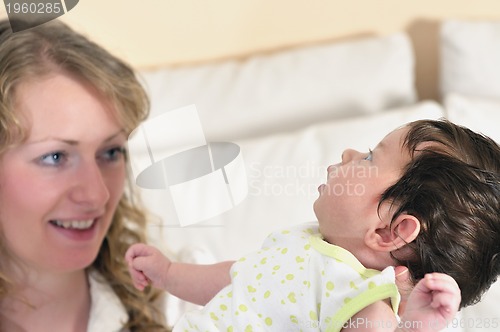 Image of beautiful young mother small with little baby