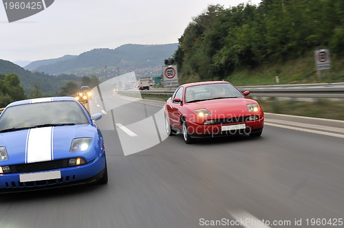 Image of Tuning cars sacing down the highway