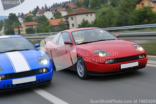 Image of Tuning cars sacing down the highway