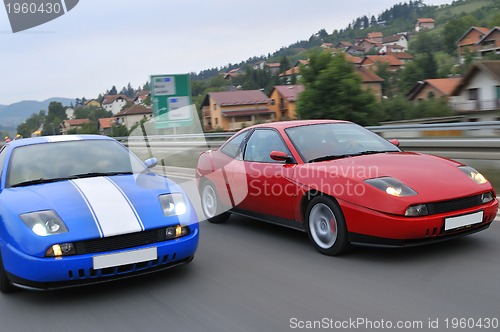 Image of Tuning cars sacing down the highway