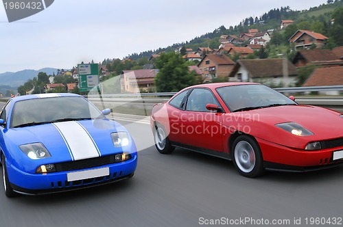 Image of Tuning cars sacing down the highway