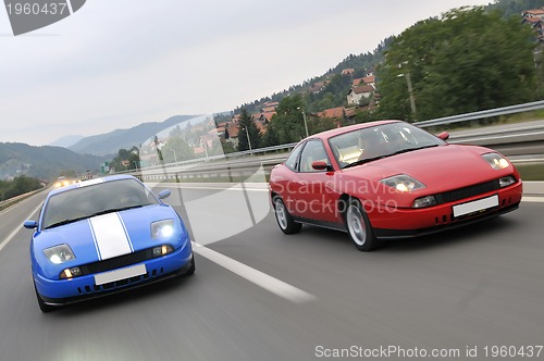 Image of Tuning cars sacing down the highway