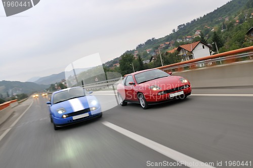 Image of Tuning cars sacing down the highway