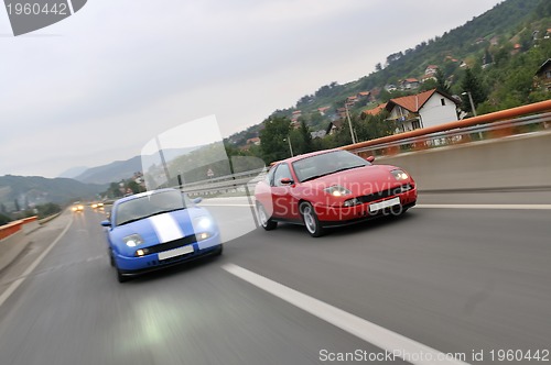 Image of Tuning cars sacing down the highway