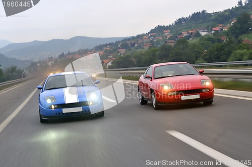 Image of Tuning cars sacing down the highway