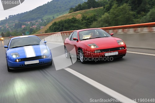 Image of Tuning cars sacing down the highway