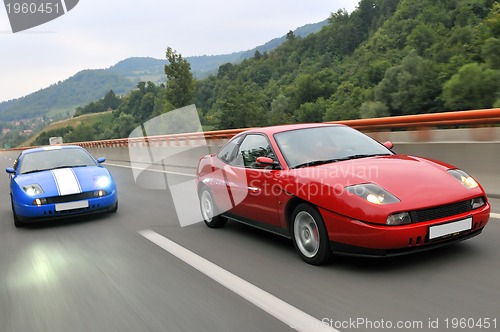 Image of Tuning cars sacing down the highway