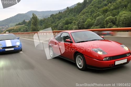 Image of Tuning cars sacing down the highway