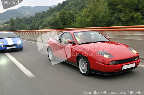 Image of Tuning cars sacing down the highway