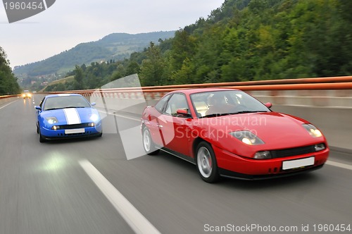 Image of Tuning cars sacing down the highway