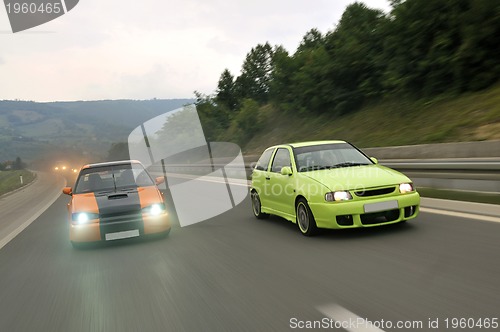 Image of Tuning cars sacing down the highway