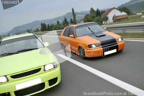 Image of Tuning cars sacing down the highway