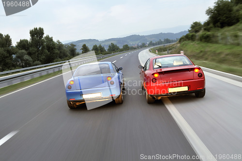 Image of Tuning cars sacing down the highway