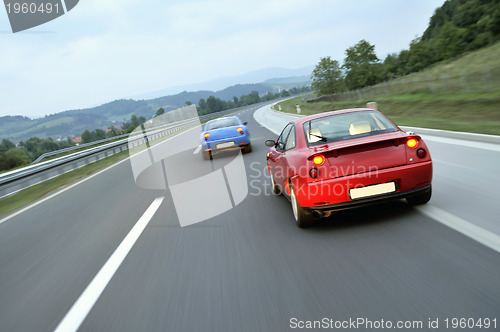 Image of Tuning cars sacing down the highway