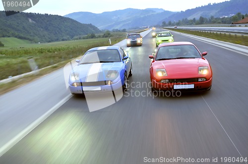 Image of Tuning cars sacing down the highway