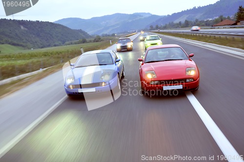 Image of Tuning cars sacing down the highway