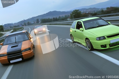 Image of Tuning cars sacing down the highway