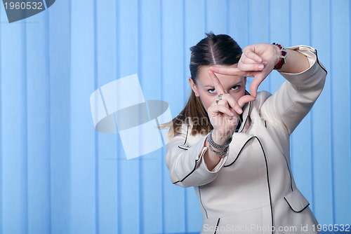 Image of portrait of young business woman creates a frame with her hands