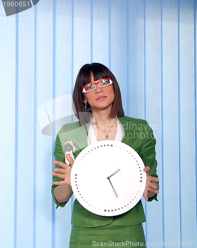 Image of .a pretty business woman hiding behind a clock