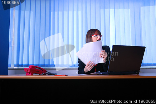 Image of .angry businesswoman holding documents