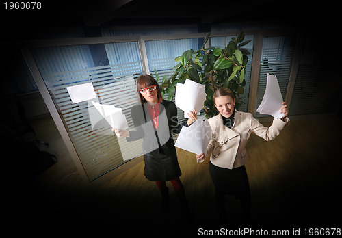 Image of two businesswoman throw papers in office