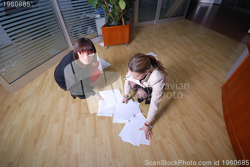 Image of two businesswoman throw papers in office