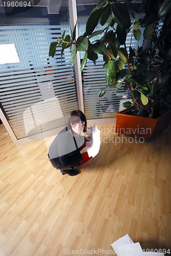 Image of happy businesswoman throwing documents in office