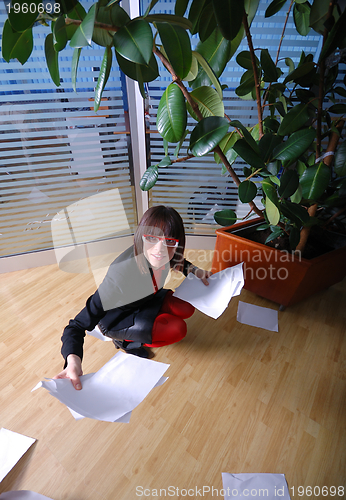 Image of happy businesswoman throwing documents in office