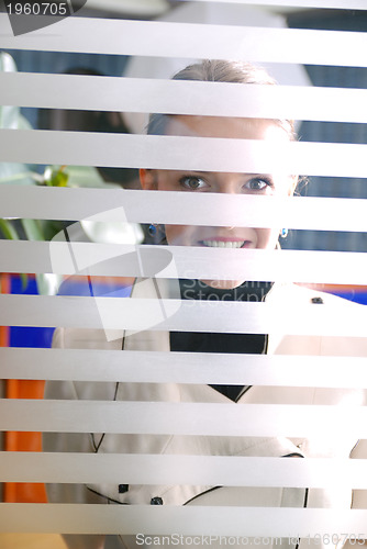 Image of young businesswoman looking trought transparent wall