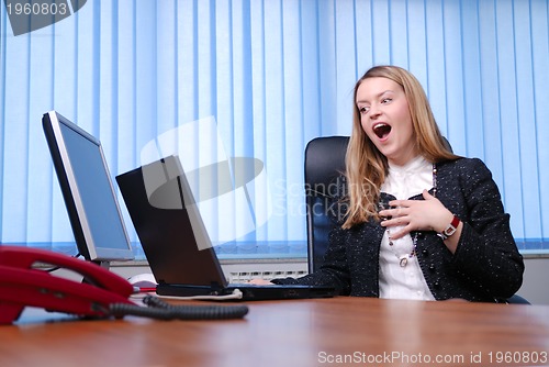Image of Smiling young businesswoman working on a laptop in the office.