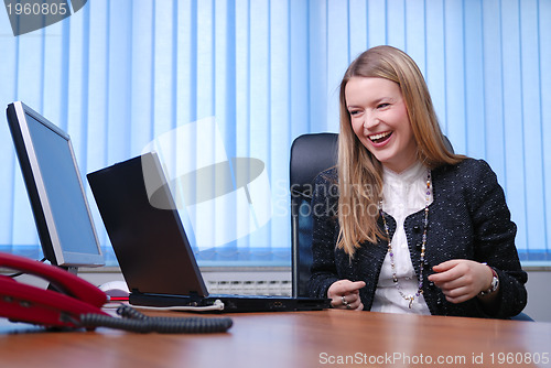 Image of Smiling young businesswoman working on a laptop in the office.