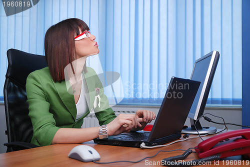 Image of Smiling young businesswoman working on a laptop in the office.