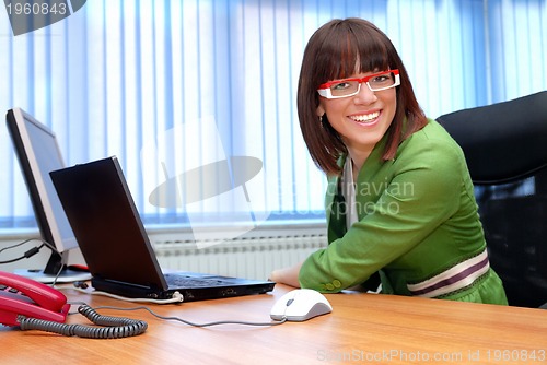 Image of Smiling young businesswoman working on a laptop in the office.