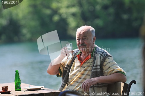 Image of senior man eat desser at outdoor restaurant