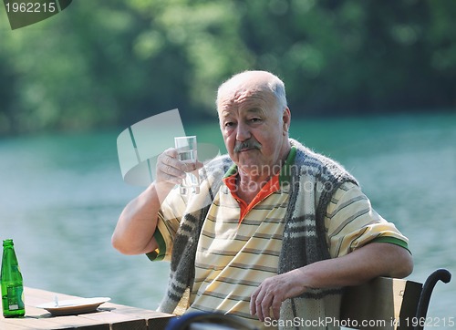 Image of senior man eat desser at outdoor restaurant